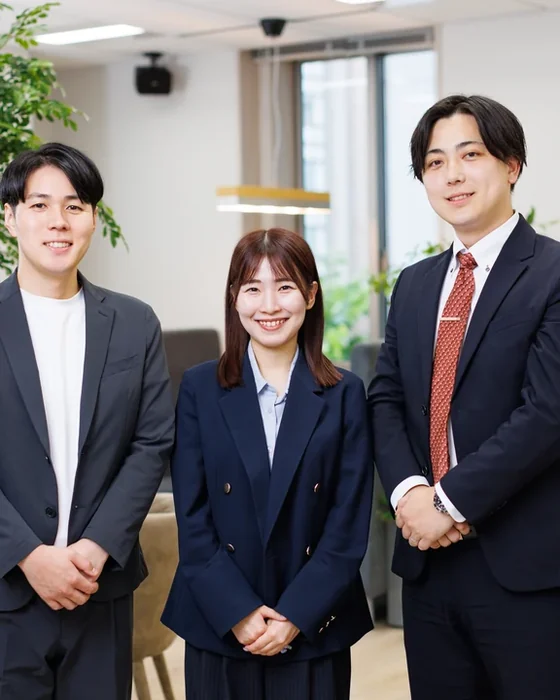 打ち合わせスペースに立つ社員3名